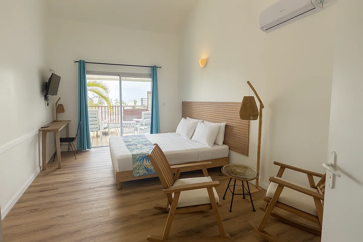 Studio vue mer avec fauteuils en bois et lampe en rotin