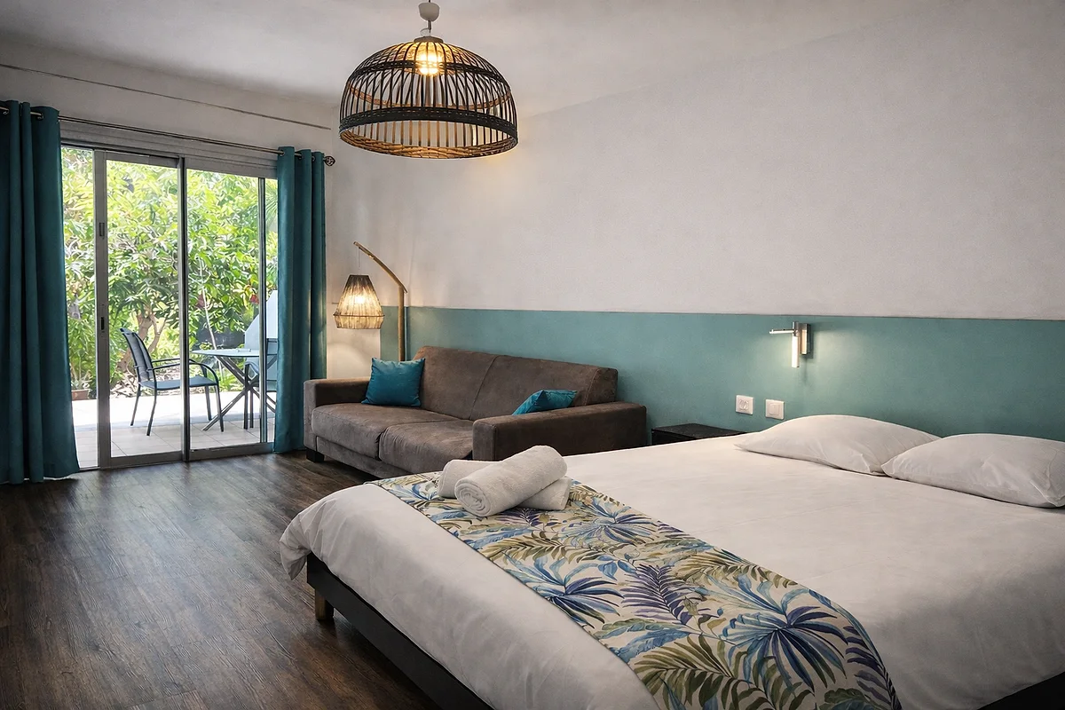 Studio côté jardin : lit double, coin salon et baie vitrée sur la terrasse