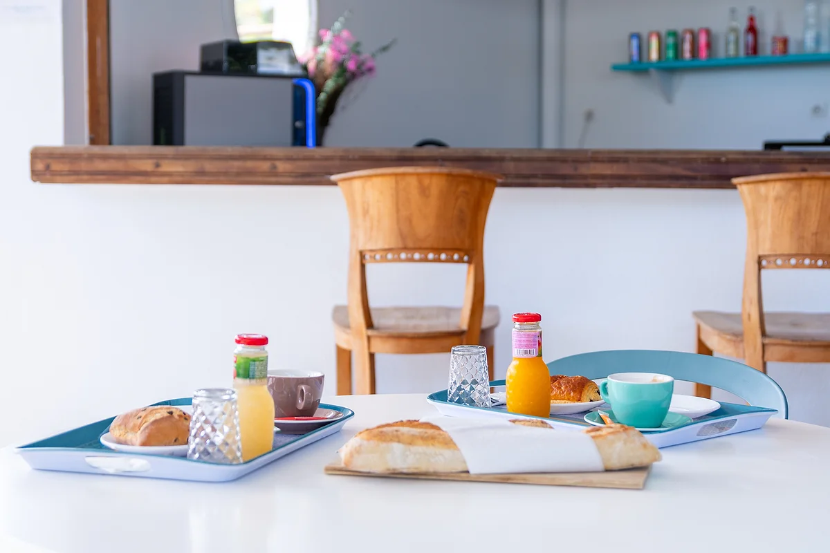 Le petit-déjeuner servi sur un plateau : viennoiseries, jus et boisson chaude