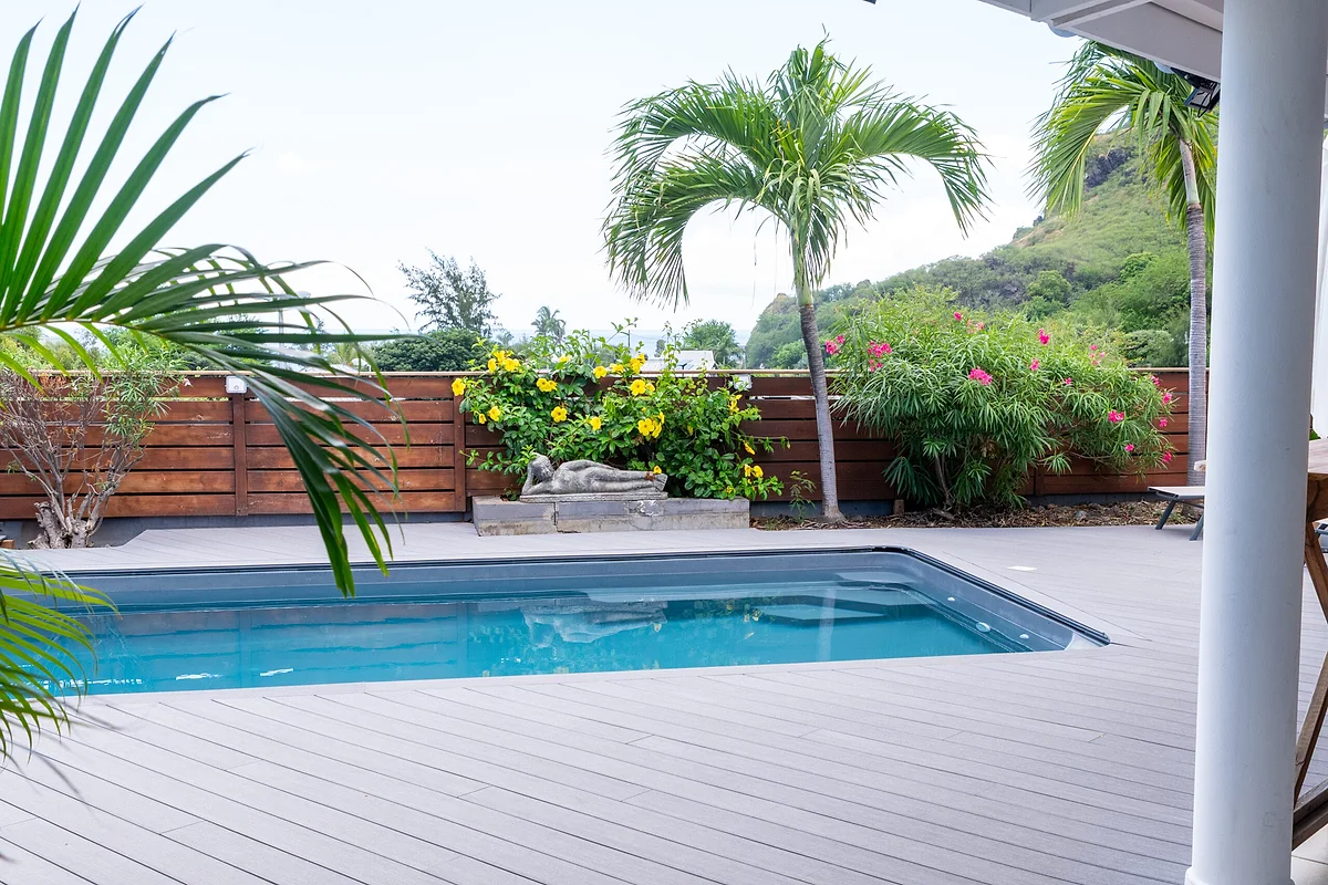 La piscine chauffée entourée de palmiers et de bougainvilliers