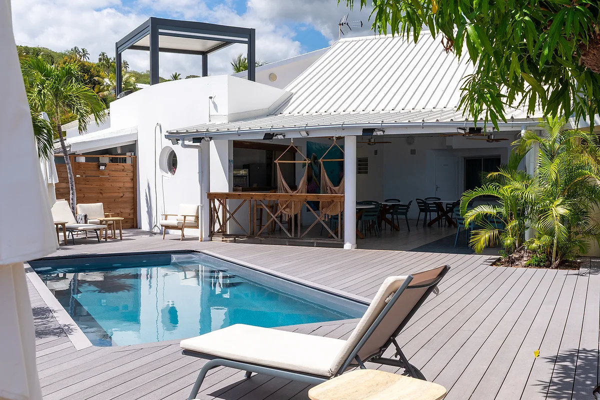La piscine chauffée de L'Ilot Bleu, ses transats sur la terrasse en bois et le bar couvert