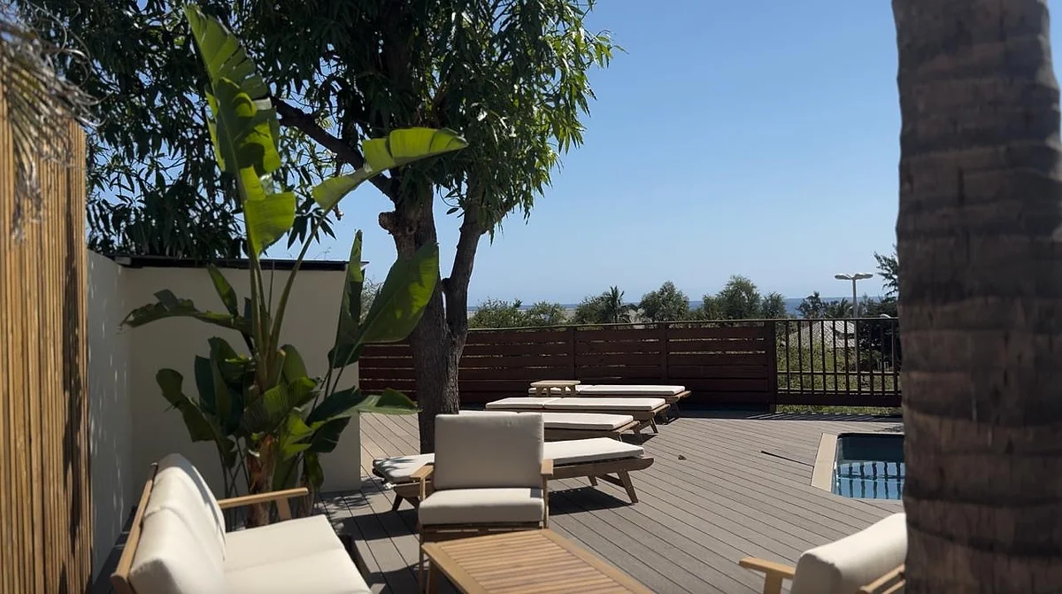 Une terrasse de L'Ilot Bleu avec ses transats, et l'océan au loin